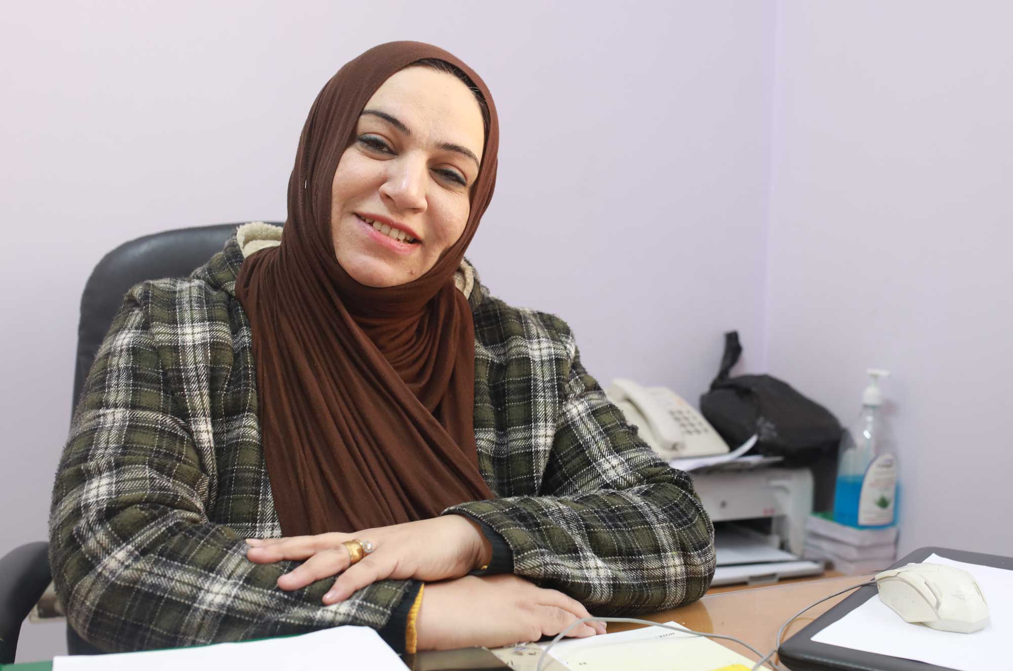 Soha Mosa sitting at her desk. She is a psychologist and therapist who works at the Women’s Health Centre in Jabaliya, Gaza.