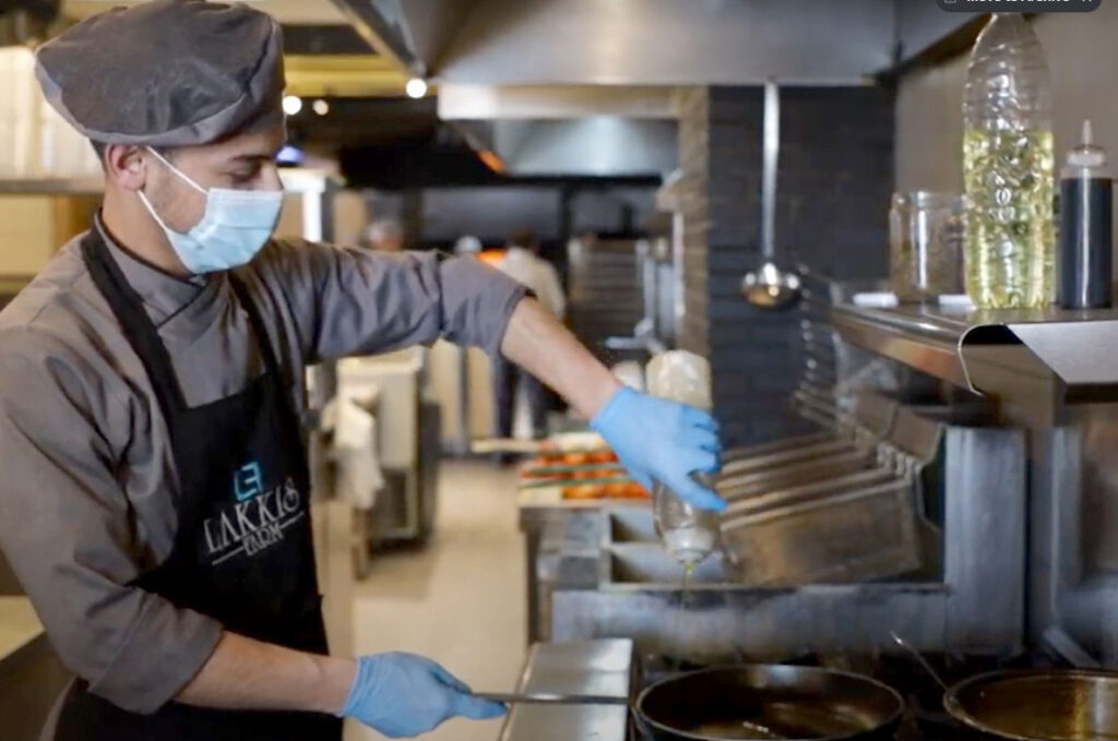 Anera hospitality course graduate in Lebanon pours oil into a pan