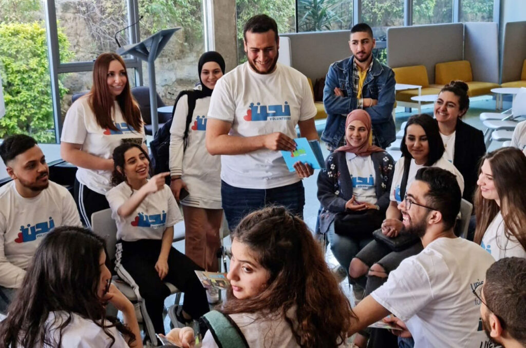 Ahmad stands amid a group of youth in Nahno-Volunteers shirts.