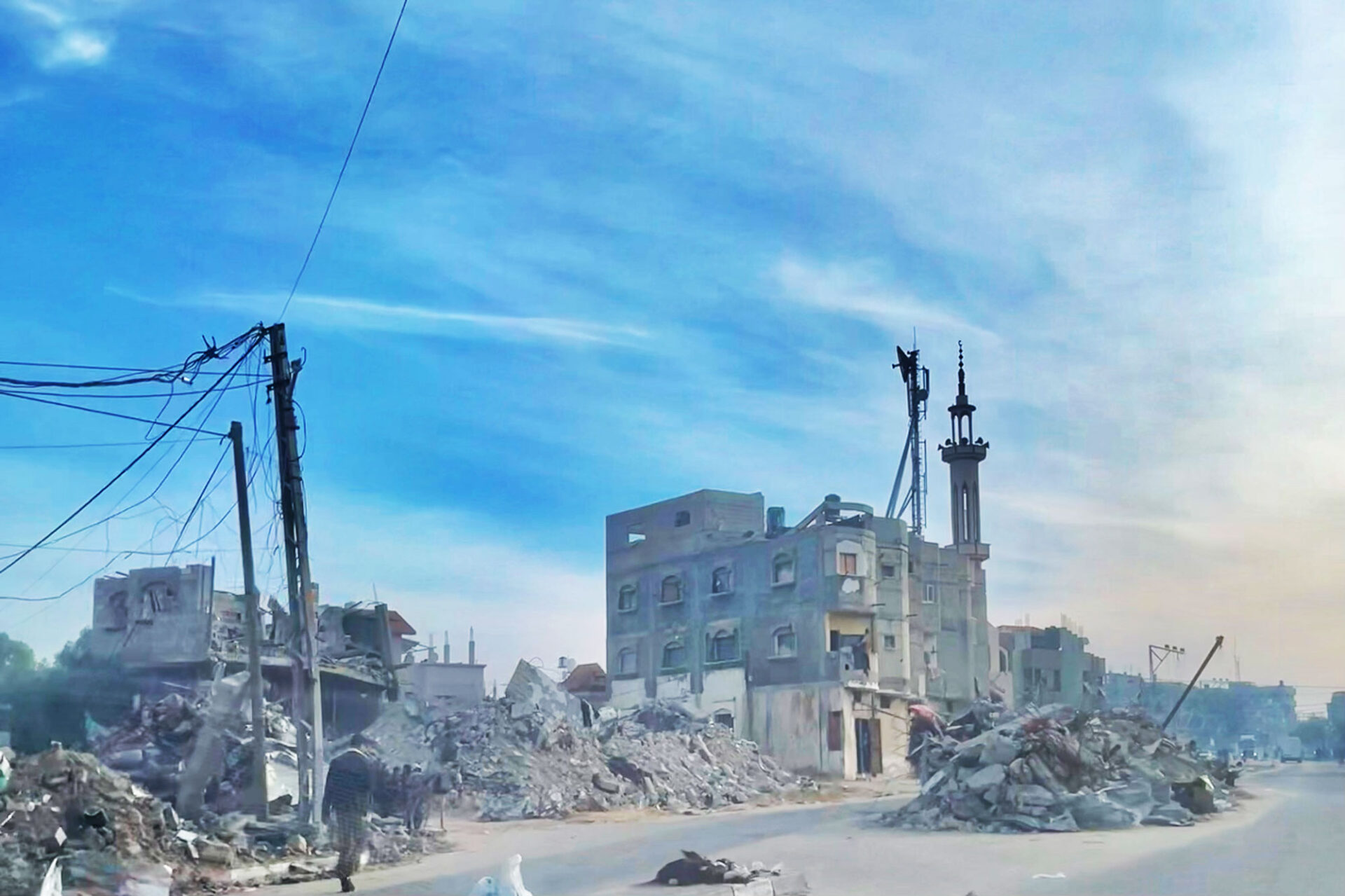 A view of the skyline reveals a partially standing building and piles of rubble around it from former buildings.