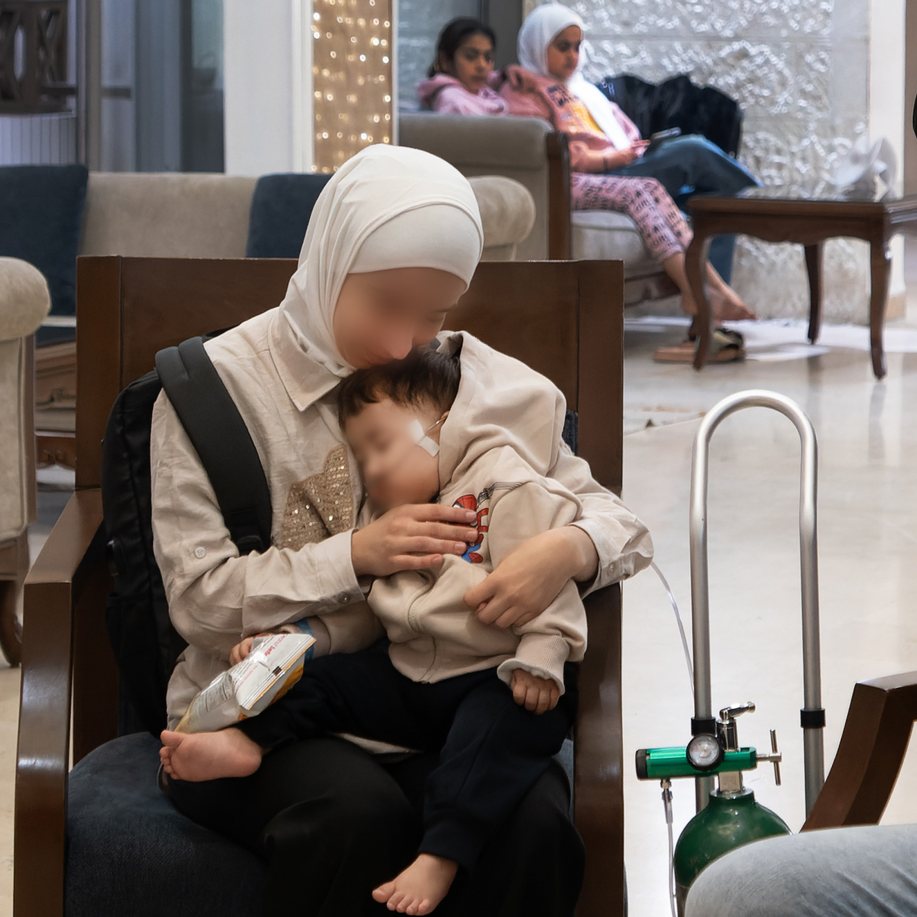Mother cradles her young sick child in a hospital waiting room