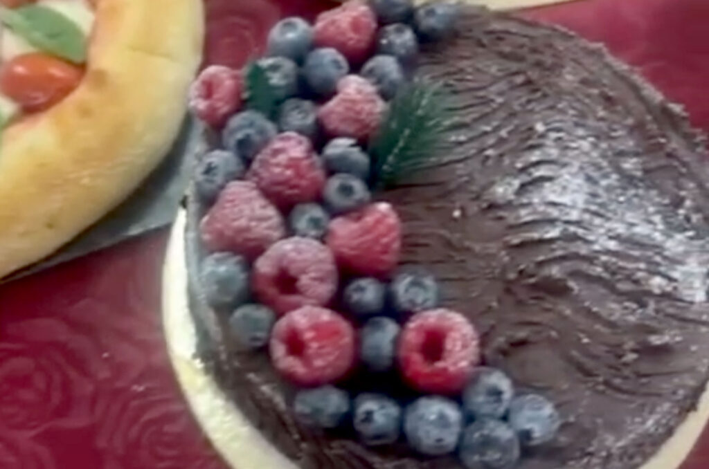 The buffet table of dishes and desserts is shown, including pizzas, cakes and cookies.