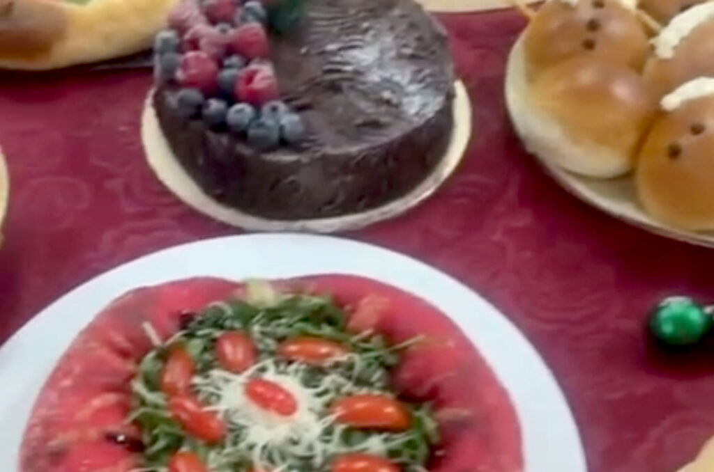 The buffet table of dishes and desserts is shown, including pizzas, cakes and cookies.