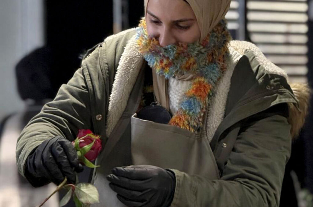 A student in Anera's floristry course trims roses.