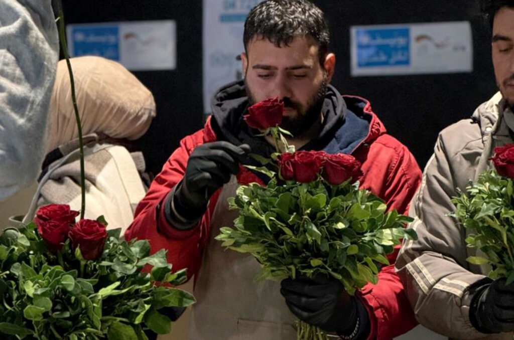 A student in Anera's floristry course forms a bouquet of roses.