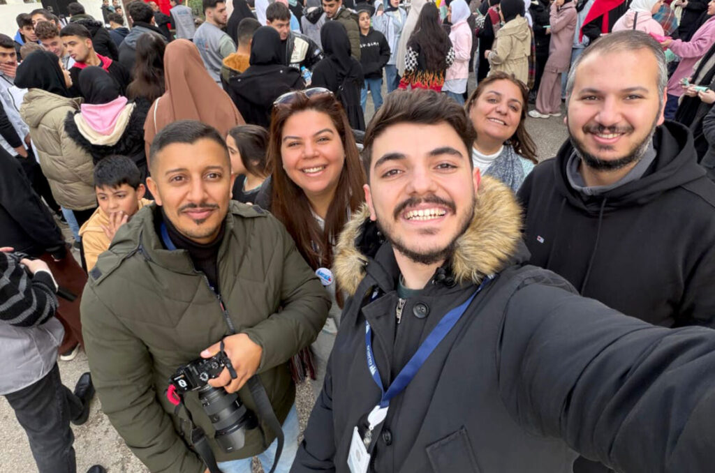Volunteers at the Greener Lebanon event are shown in a large crowd.