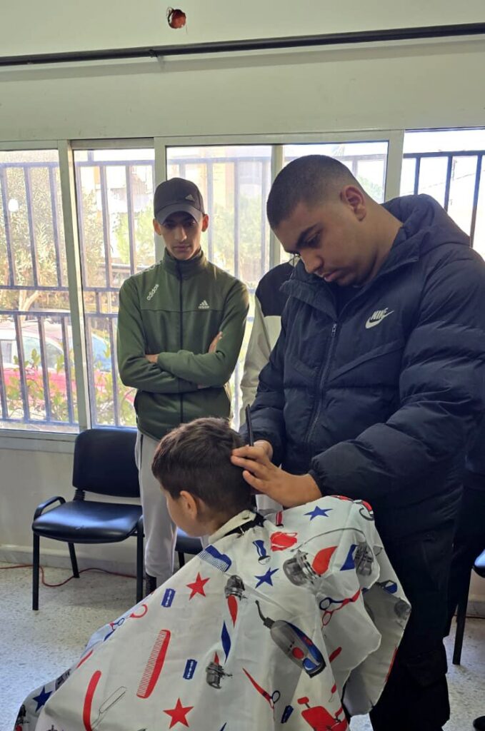 trainee cutting a young child's hair
