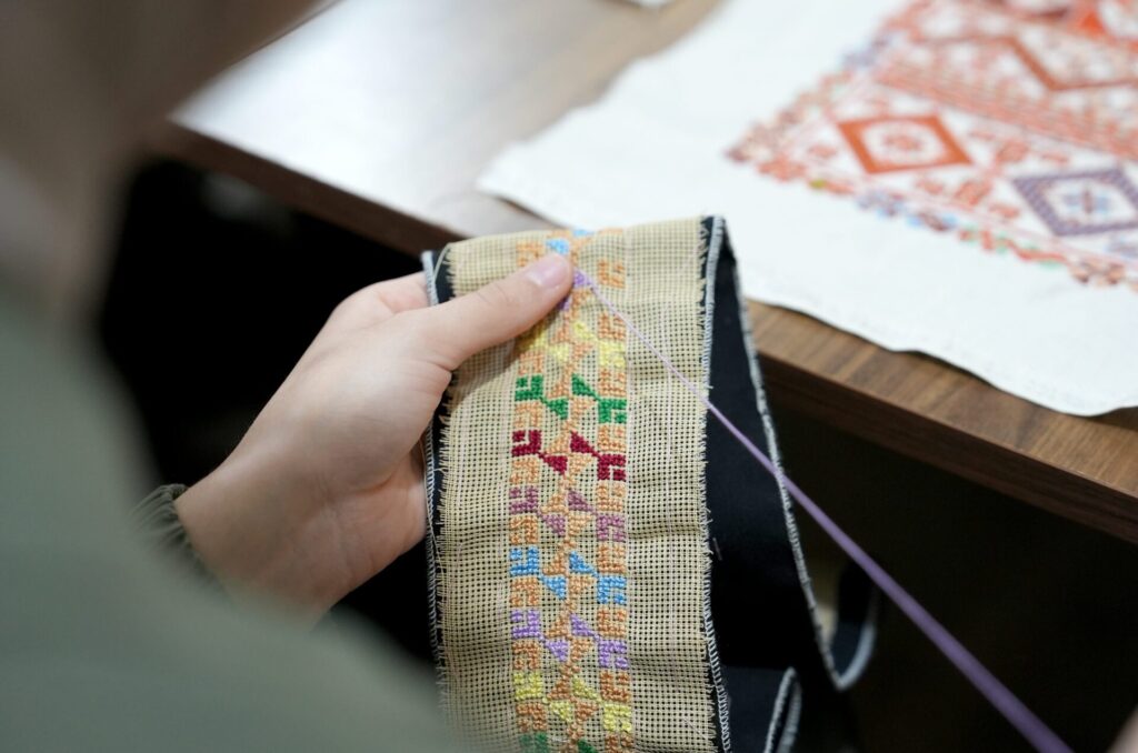 closeup of a woman stitching the traditional Palestinian tatreez
