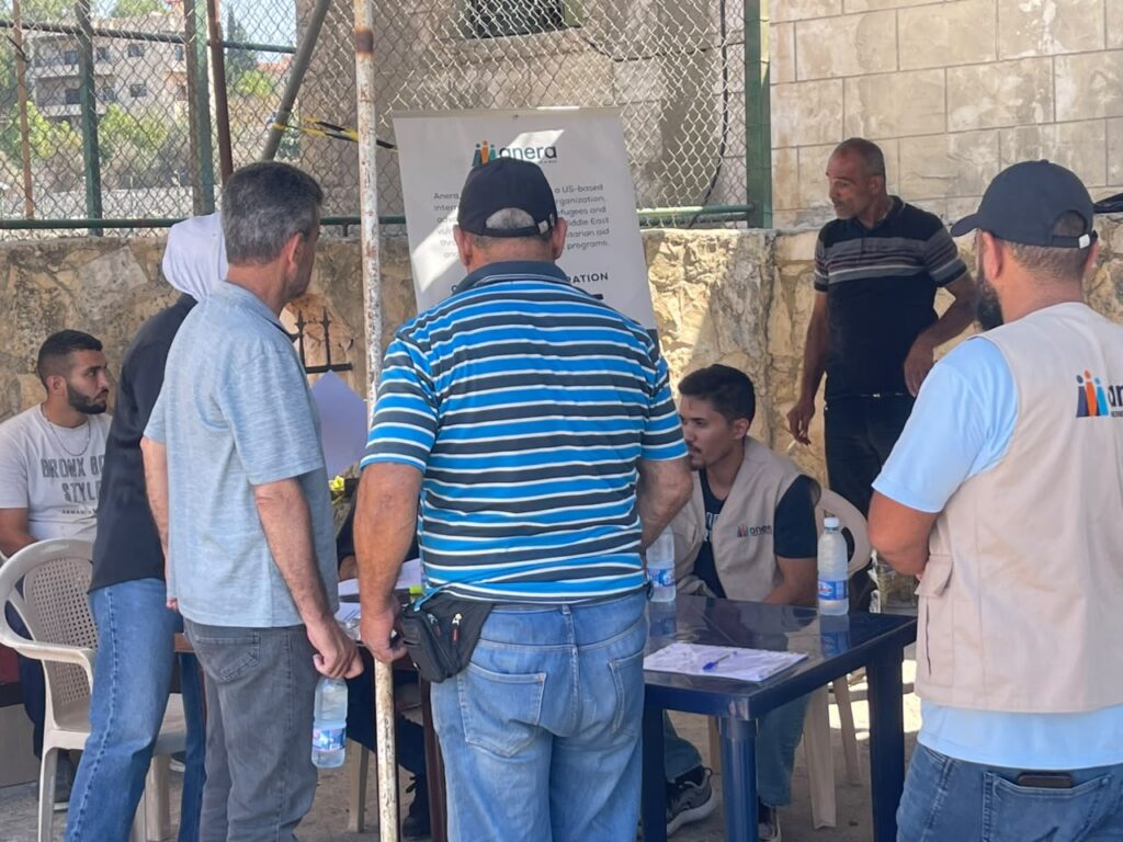 People gather around a check-in table at the distribution location.