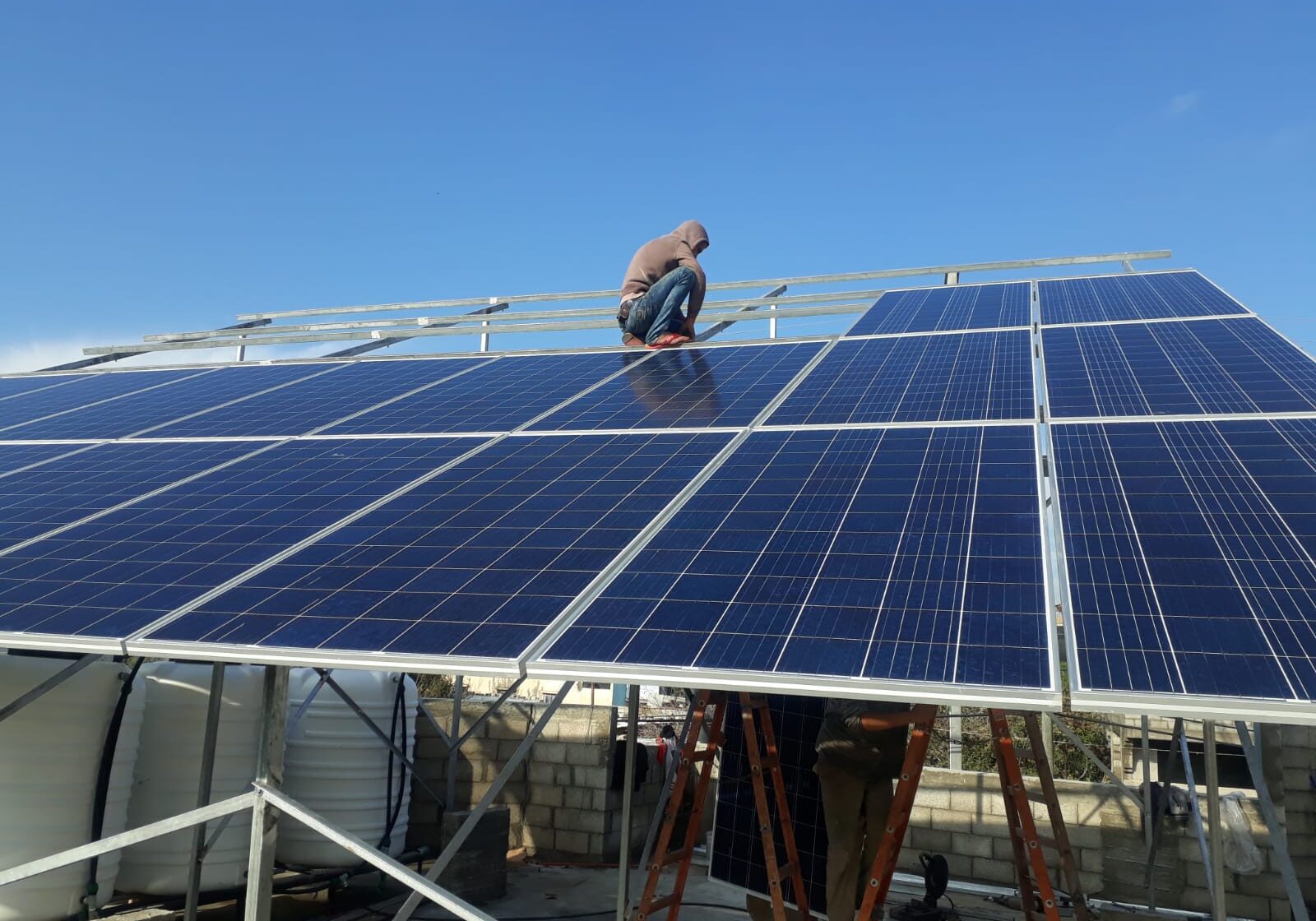 Anera workers installed solar panels on the roof of the Wounded Child Clinic, which serves 6,000 Gaza residents.