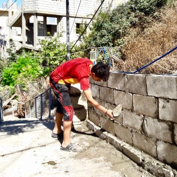 Doing mason work to build sides to the staircase.