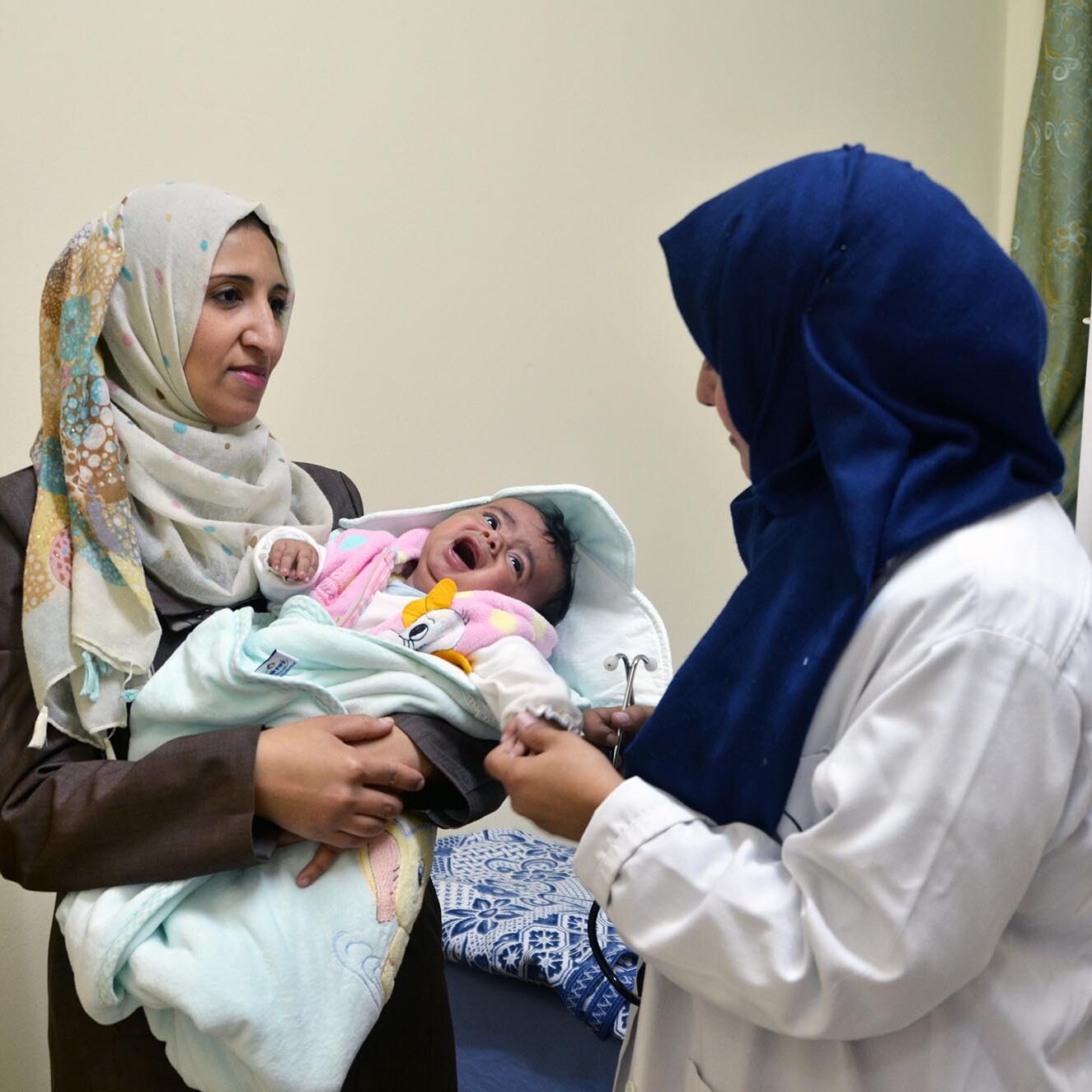 Dr. Manal Abu Jiban treats baby Kinan, using medicine distributed as part of Anera's in-kind medical aid program.