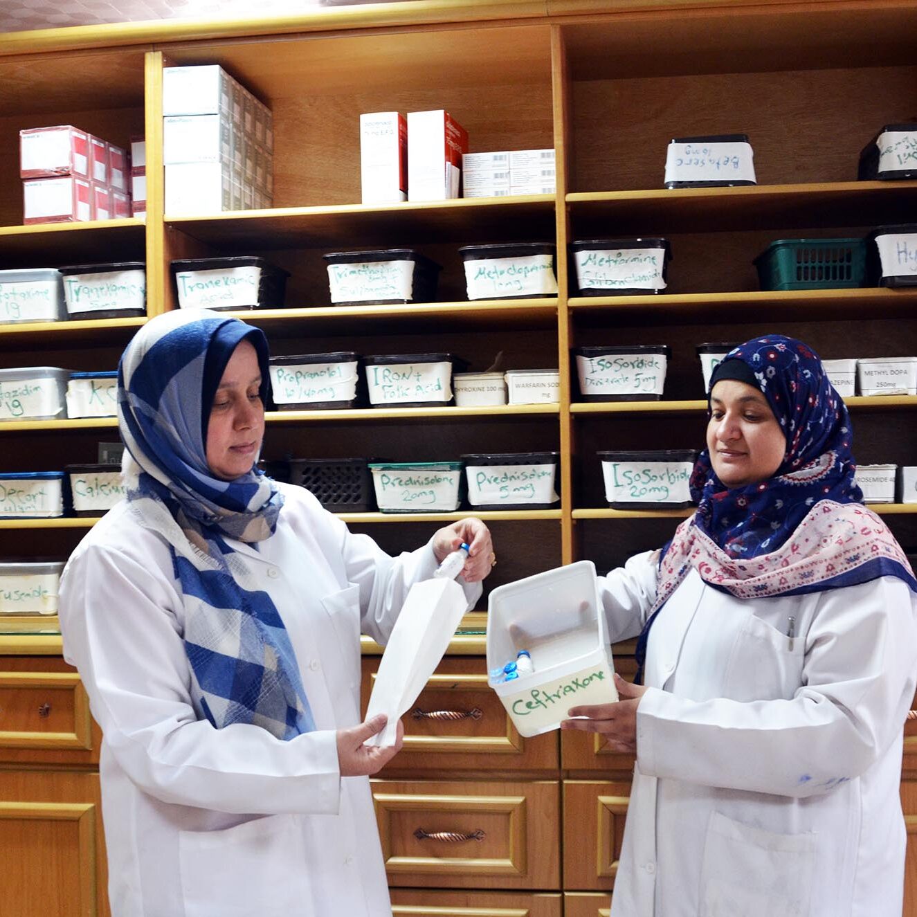 Two pharmacists sort out medicine in the central pharmacy of Al Shifa Hospital.
