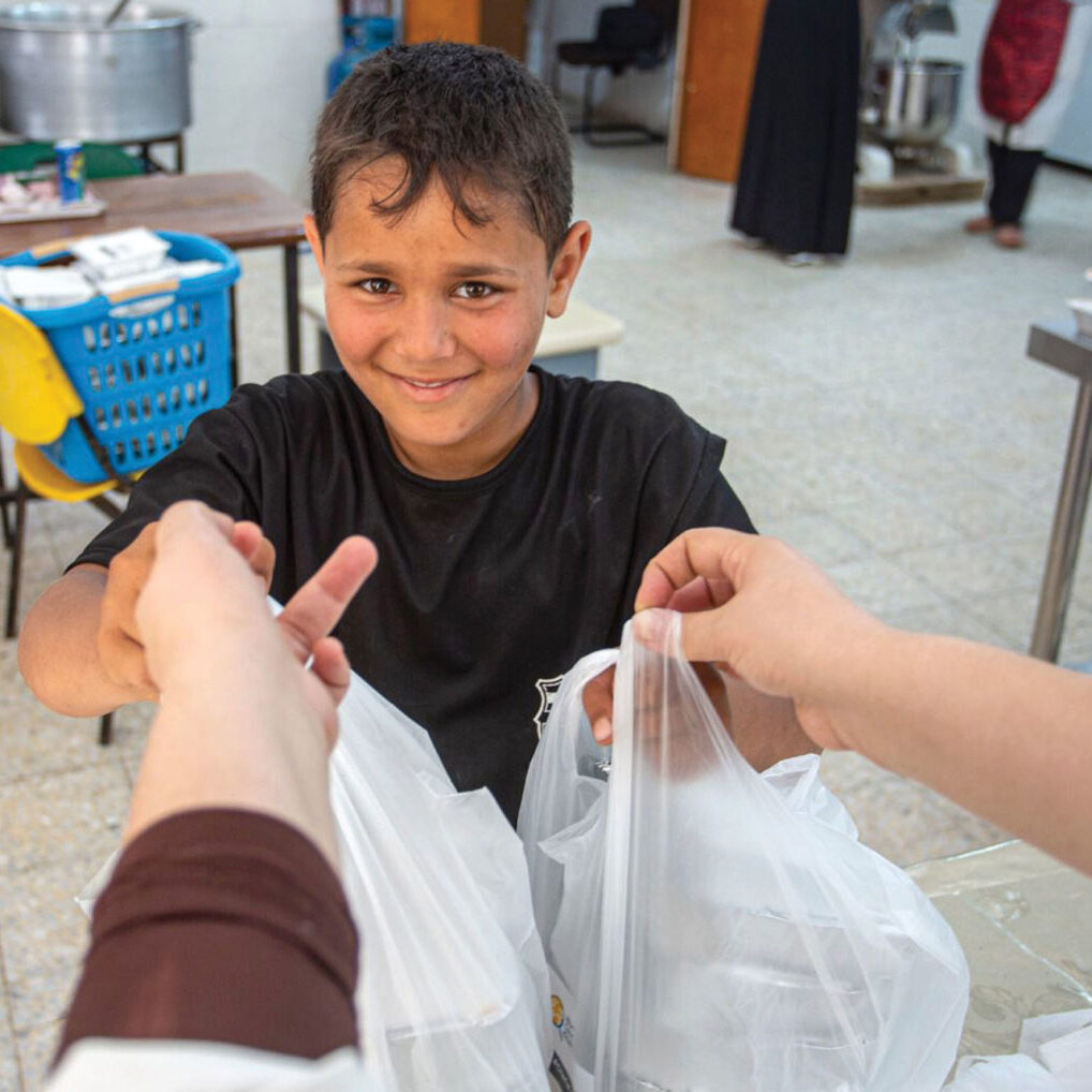 Nine-year-old Islam picks up food for his family, who saw their house destroyed in early May. Islam lives with his parents and younger siblings in Beit Hanoun, northern Gaza.