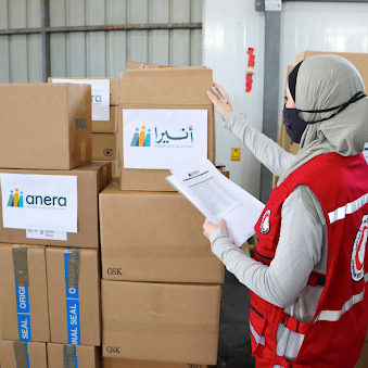 A pharmacist from the Jordanian National Red Crescent Society cross checks their approved list of medications with the medications received. 